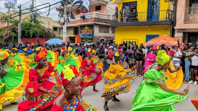 Groupe de danse haïtien défilant et dansant sur l'avenue Baranquilla lors du défilé du Carnaval de Jacmel 2026 dans le Sud-Est d'Haïti.